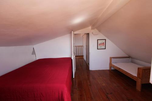 a bedroom with a red bed in a attic at Estrela Penthouse - Amazing Views in Lisbon