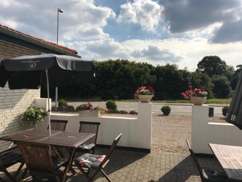 a table and chairs with an umbrella on a patio at Hotel Medio Fredericia in Fredericia
