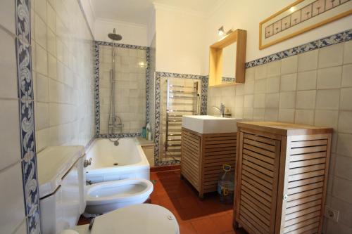 a bathroom with a toilet and a tub and a sink at Estrela Penthouse - Amazing Views in Lisbon