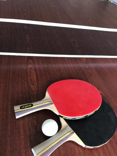 a pair of ping pong paddles on a wooden table at Hotel Medio Fredericia in Fredericia