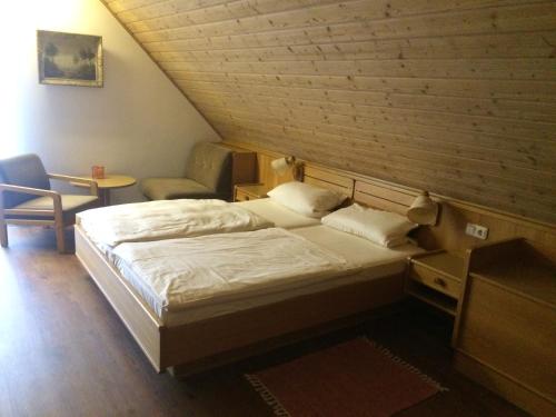 a bedroom with a bed and a chair in a room at Landgasthaus Konig in Stephanshausen