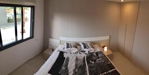 Bett in einem Zimmer mit Fenster in der Unterkunft Oasis Beach X app 25 in Guardamar del Segura