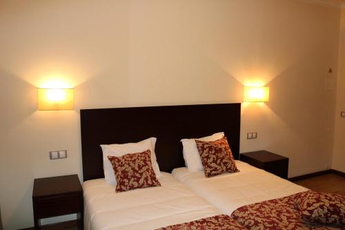 1 dormitorio con 2 camas y 2 lámparas en la pared en Paço Lafões, en Termas de Sao Pedro do Sul