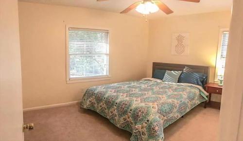 a bedroom with a bed and a ceiling fan at The Pineapple Lady 13min to Fort Benning in Columbus
