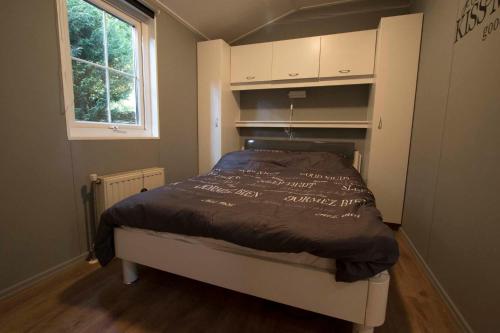 Posto letto in una piccola camera con finestra di Chalet Vakantie Wageningen Veluwe a Wageningen