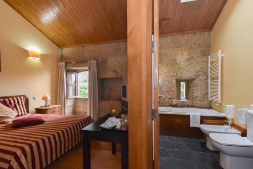 y baño con cama, lavabo y bañera. en Quinta De Abol De Baixo, en Entre -os- Rios