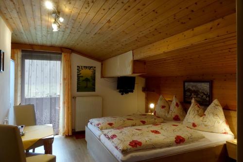 Gästehaus Zum Tauern في رادستادت: غرفة نوم بسرير في غرفة خشبية