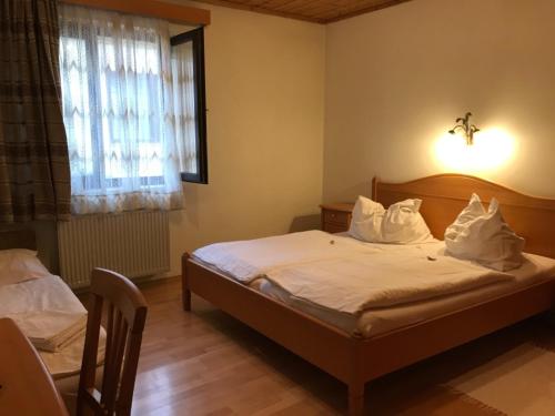 Schlafzimmer mit einem Bett mit weißer Bettwäsche und Kissen in der Unterkunft Gasthof Polly in Haunoldstein