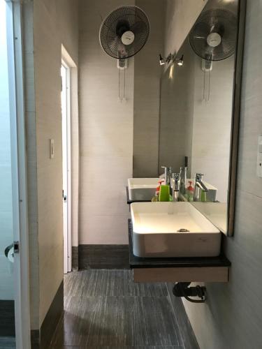 een badkamer met een witte wastafel en een spiegel bij Nhiet Doi Hotel in Tuy Hoa