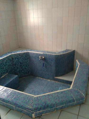 a blue tiled tub in a tiled bathroom at семеен хотел "НЕВЕН" in Momin Prohod