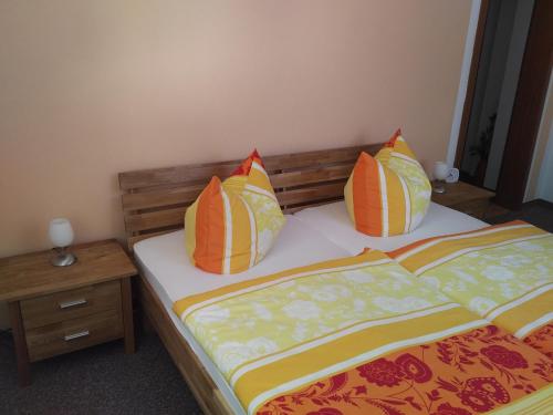 2 Betten mit bunten Kissen auf einem Zimmer in der Unterkunft Fewo am Personenaufzug in Bad Schandau