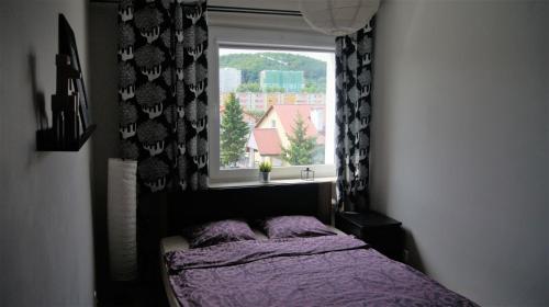 グディニャにあるApartament 22のベッドルーム(紫色のベッド1台、窓付)