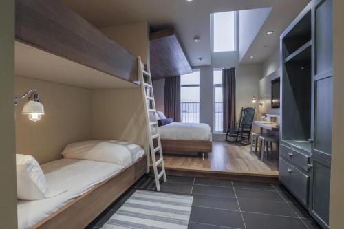 a bedroom with two bunk beds and a kitchen at Hôtel & Spa Le Germain Charlevoix in Baie-Saint-Paul
