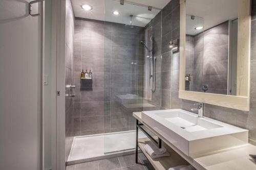 a bathroom with a sink and a shower at Hôtel & Spa Le Germain Charlevoix in Baie-Saint-Paul