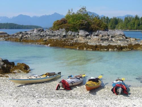 three boats sitting on a beach next to the water at 203 at Water's Edge in Ucluelet
