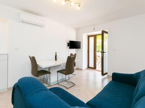 a living room with a blue couch and a table at Ninas - free wine&spirit tasting in Višnjan