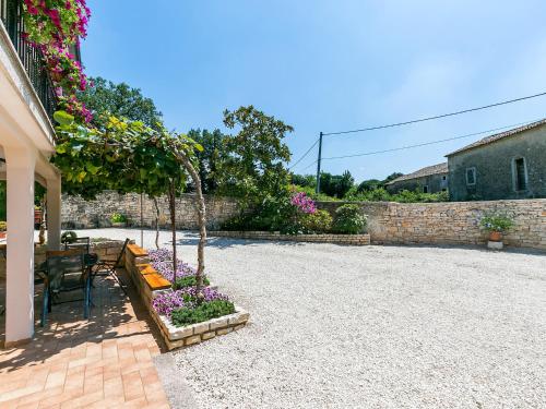 a patio with a table and flowers in a yard at Ninas - free wine&spirit tasting in Višnjan