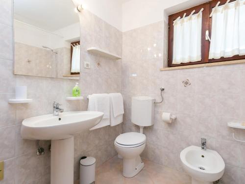 uma casa de banho branca com um WC e um lavatório em Ninas em Visnjan