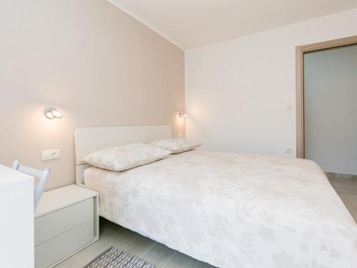 um quarto branco com uma cama branca e uma janela em Ninas em Visnjan