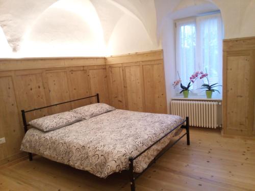 a bed in a room with a window and a bedvisor at Da Valentina in Castelfondo