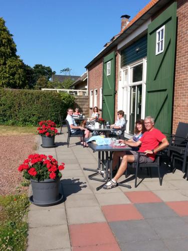 a group of people sitting at tables on a patio at Duinoord Oostkapelle in Oostkapelle