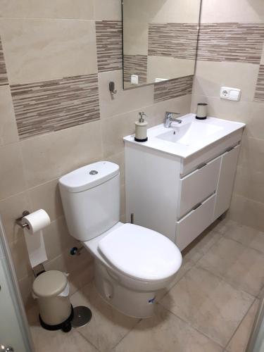 a bathroom with a white toilet and a sink at Casa sol in Vélez-Málaga