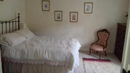 a bedroom with a bed and a chair at Hills Farm B&B Laugharne in Laugharne