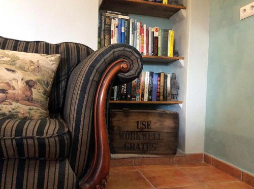 a chair with a pillow next to a book shelf at Los Cuatro Vientos B&B in Torre del Rico