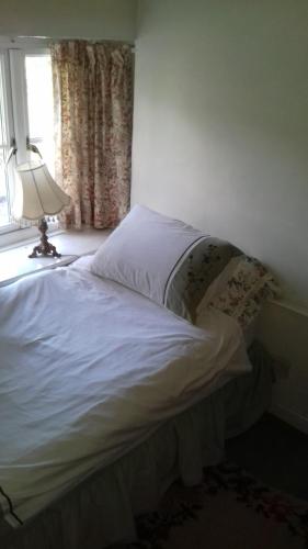 a bed with a white comforter and pillows at Hills Farm B&B Laugharne in Laugharne