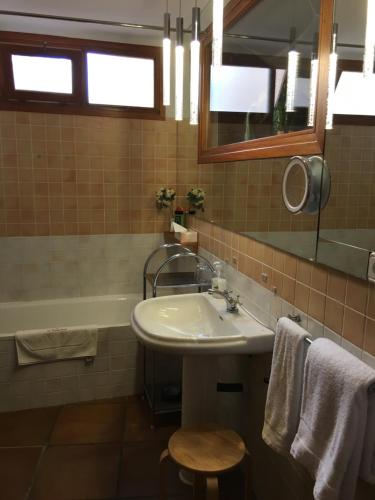 uma casa de banho com um lavatório, uma banheira e um espelho. em Finca El Almendral em Relleu