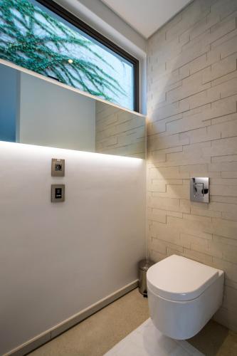 ein Bad mit einem weißen WC und einem Fenster in der Unterkunft Livega House in Windhoek