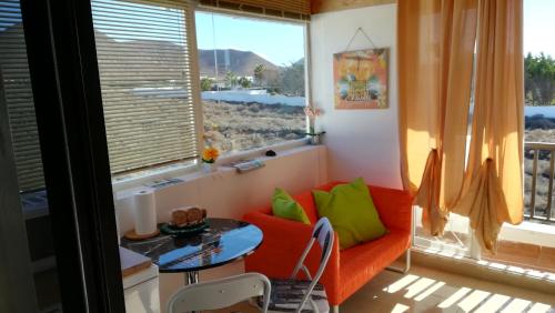 a living room with a couch and a table and a window at Alma en el Mar in Tinajo