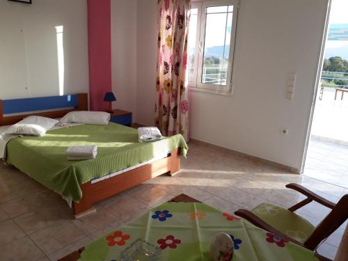 a bedroom with a bed with a green bedspread at Iremia Rooms in Adamantas