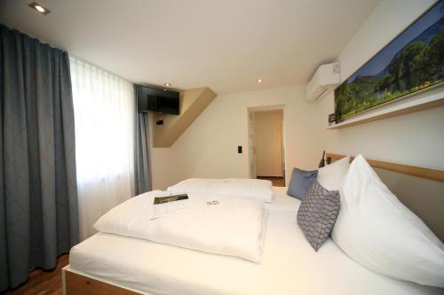 a bedroom with two beds with white sheets at Hotel Halfenstube & Villa Spa 1894 in Senheim