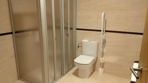 a bathroom with a toilet and a shower stall at Hotel Nordés in Burela de Cabo