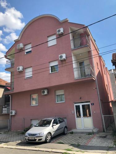 a car parked in front of a red building at Cozy studio Belgrade (Zemun) in Belgrade