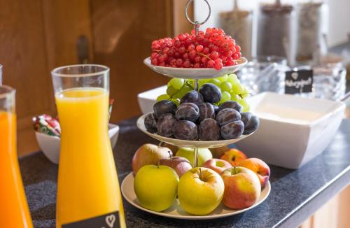 a display of fruit on a counter with two plates of fruit at Haus Drei Linden in Going