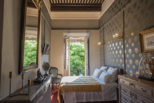 a bedroom with a bed and a dresser and a mirror at Les suites de Peyrat in Pézenas