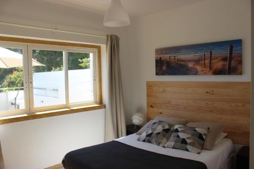 a bedroom with a bed and a window at Encosta´s Garden in Oeiras