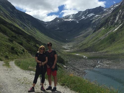 a man and woman standing on a dirt road in a valley at Appartements Olympia in Mayrhofen