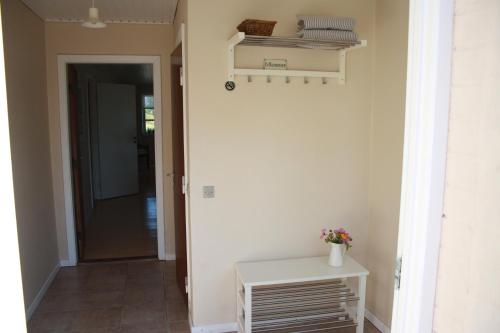 a hallway with a door and a table with flowers at Sønderborg Kær Vestermark in Sønderborg