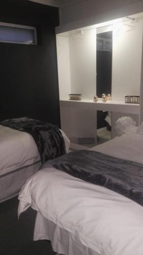 a bedroom with two beds and a mirror at Dankbaar in Bloemfontein