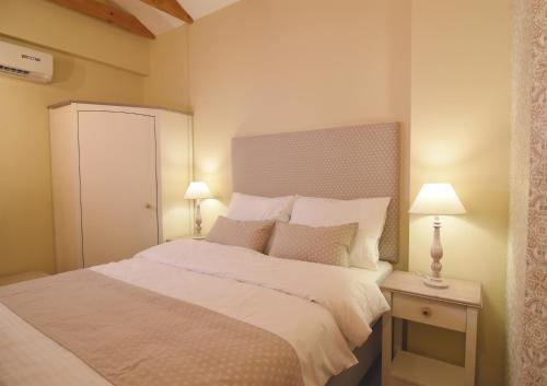 Janez Rooms في ليوبليانا: غرفة نوم بسرير ابيض كبير ومصباحين