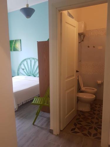 a bathroom with a bed and a toilet in a room at Casanoemi 1 in Cagliari