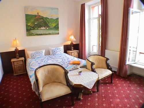 1 Schlafzimmer mit einem Bett, 2 Stühlen und einem Tisch in der Unterkunft Union Hotel Cochem in Cochem