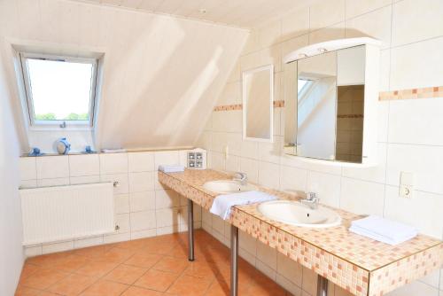 a bathroom with two sinks and a mirror at Lüggerts in Ennigerloh