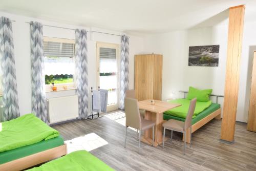 a room with two beds and a table and chairs at Lüggerts in Ennigerloh