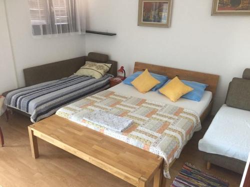 een kleine slaapkamer met een bed en een bank bij Apartment Subota in Mali Lošinj