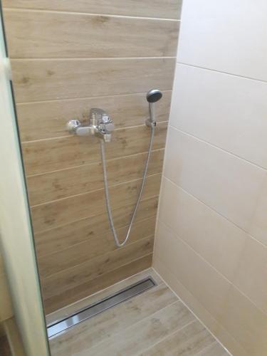une douche avec un tuyau fixé à un mur dans l'établissement Apartman Katedrala, à Sarajevo