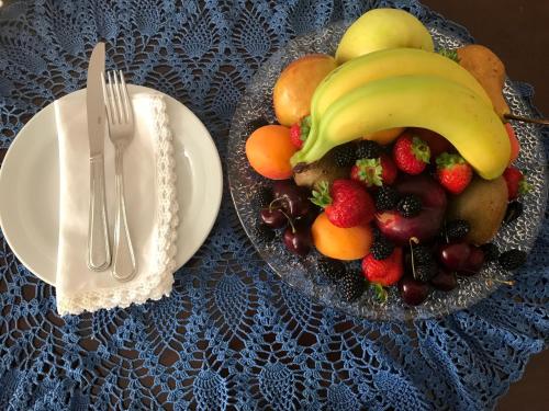 a plate of fruit on a table with a fork and knife at Navona Gallery Suites in Rome